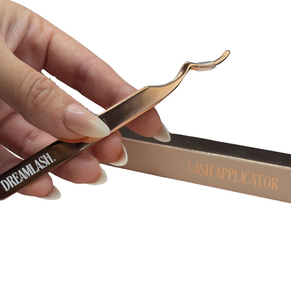 Lash applicator with 'Dreamlash' branding held by a hand on a white background
